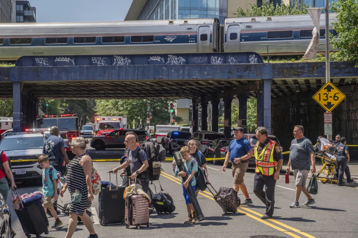 Emergency workers help passengers with their bags while disembarking a supplemental train after their Amtrak train derailed near Union Station in Washington on July 11, 2023. (Nathan Howard/AP Photo)
