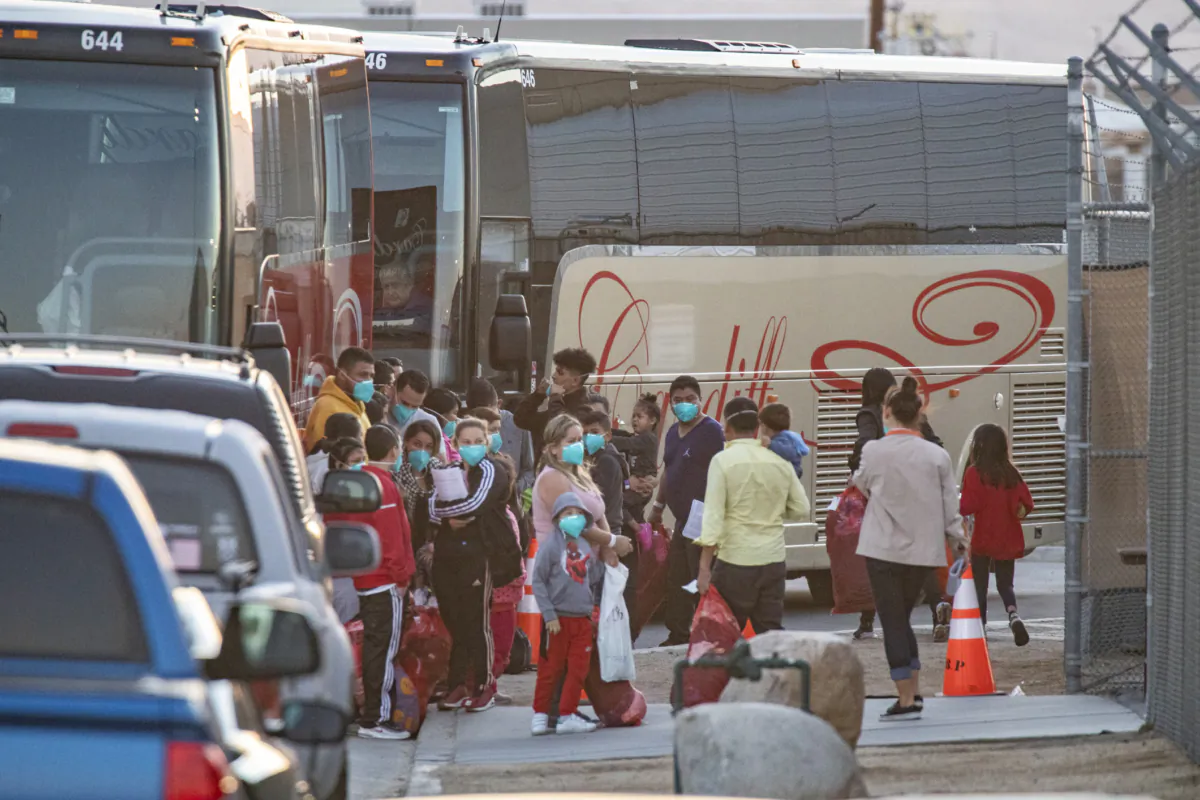Immigrants are moved onto cater buses and transfered to a migrant shelter in Indio, Calif., on Oct. 18, 2021. (John Fredricks/The Epoch Times)