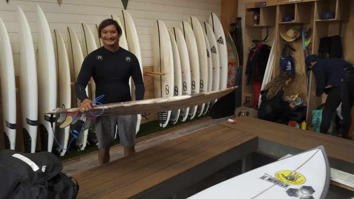 Mikala Jones at Surf Ranch in Lemoore, Calif., on May 19, 2019, holding a surfboard his brother Daniel Jones made using material from the agave plant. (Dr. John Jones via AP)