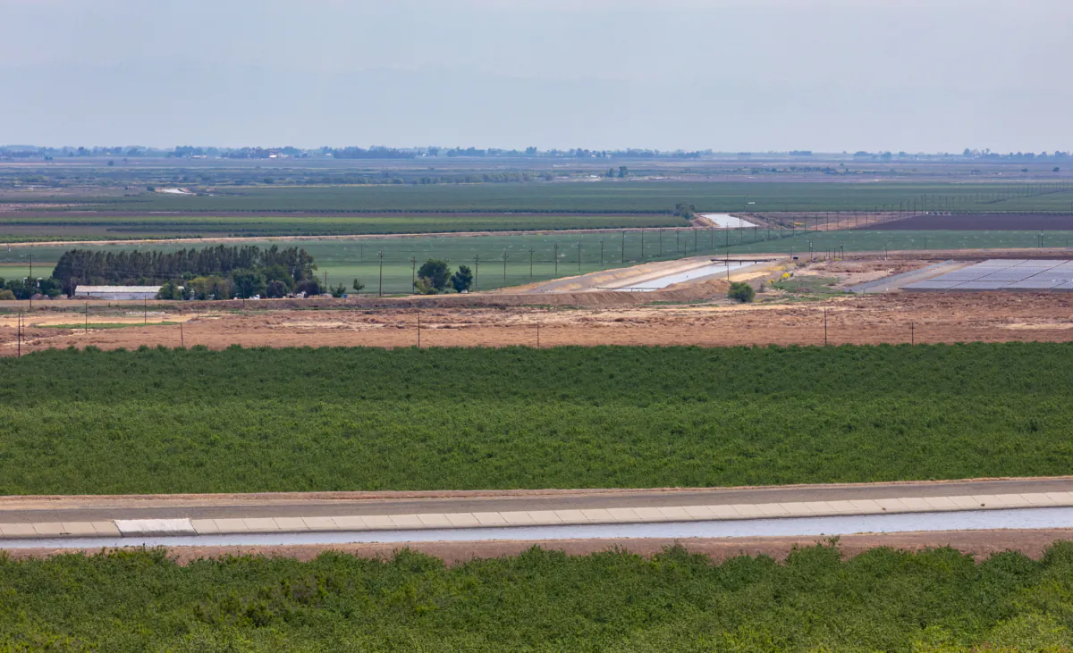 The California Aquaduct (foreground) sits adjacent to farmland outside of Sacramento, Calif., on April 18, 2022. (John Fredricks/The Epoch Times)