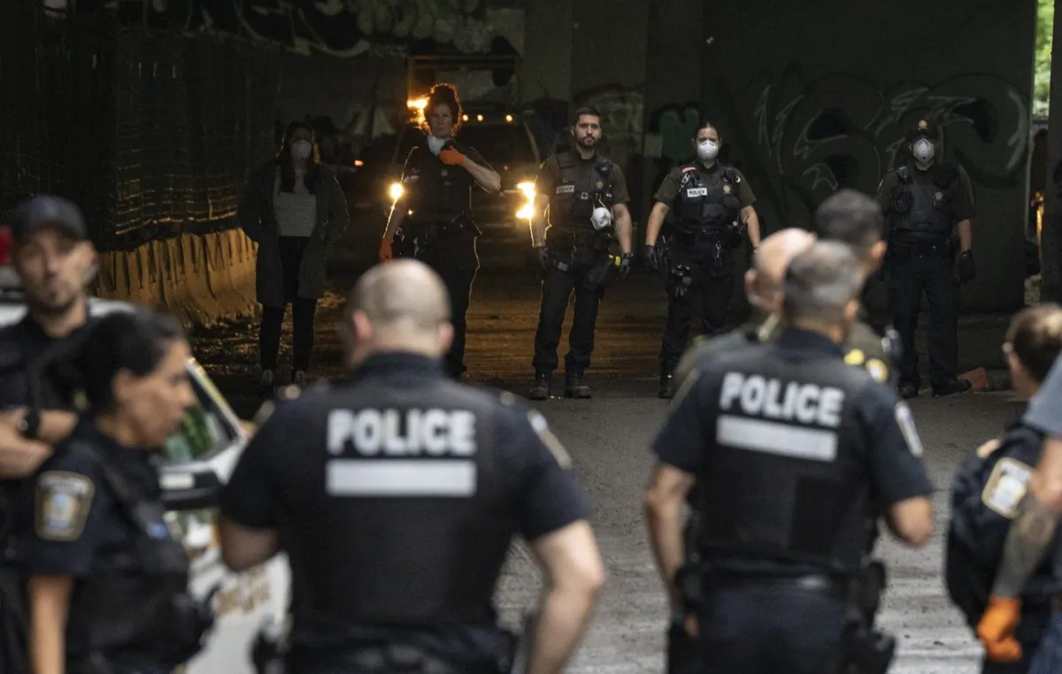 Quebec provincial police officers block an underpass during an eviction of a homeless encampment under the Ville-Marie expressway in Montreal, July 11, 2023. (The Canadian Press/Christinne Muschi)
