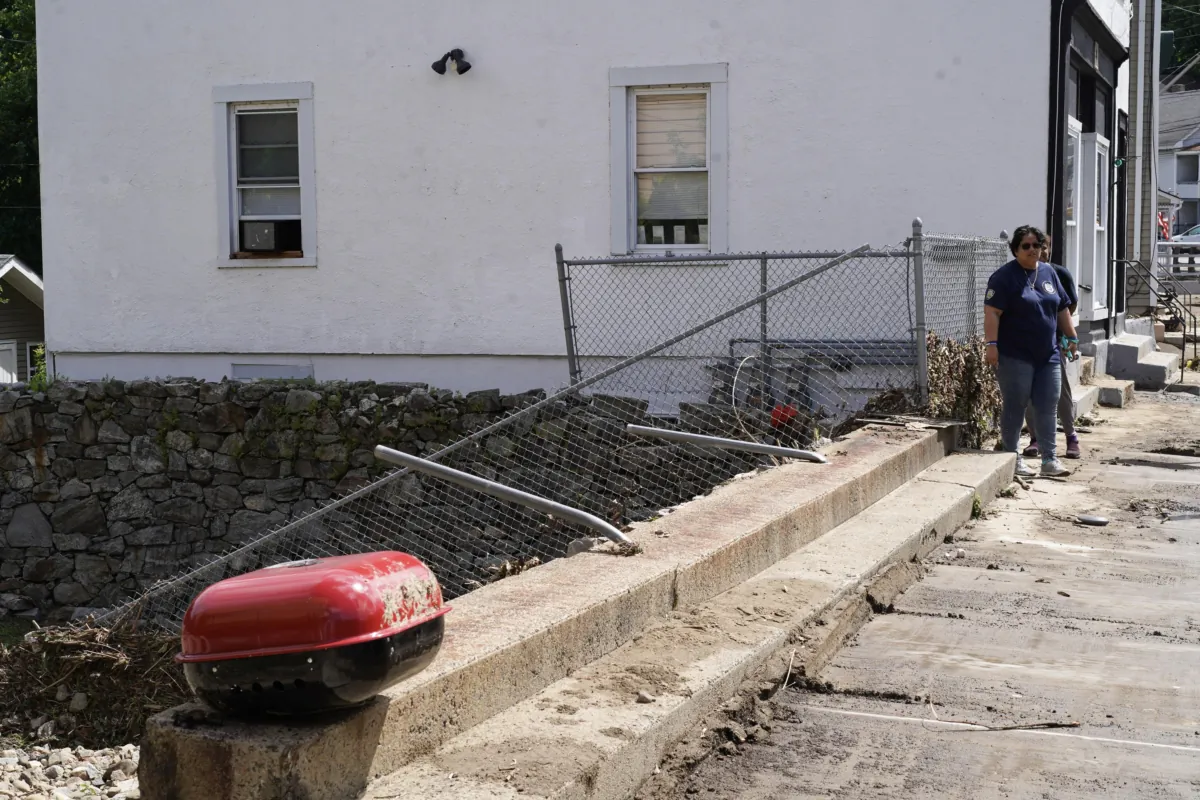 A broken metal fence that was pushed apart by a historic flood the day before in Highland Falls, N.Y., on July 10, 2023. (Cara Ding/The Epoch Times)