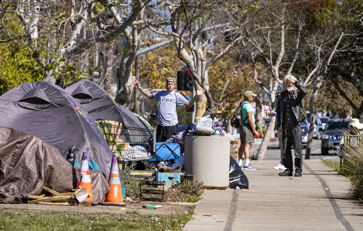 Men emerge from their tents located in a homeless encampment in front of the Venice Beach Library in Venice Beach, Calif., on Feb. 18, 2022. (John Fredricks/The Epoch Times)