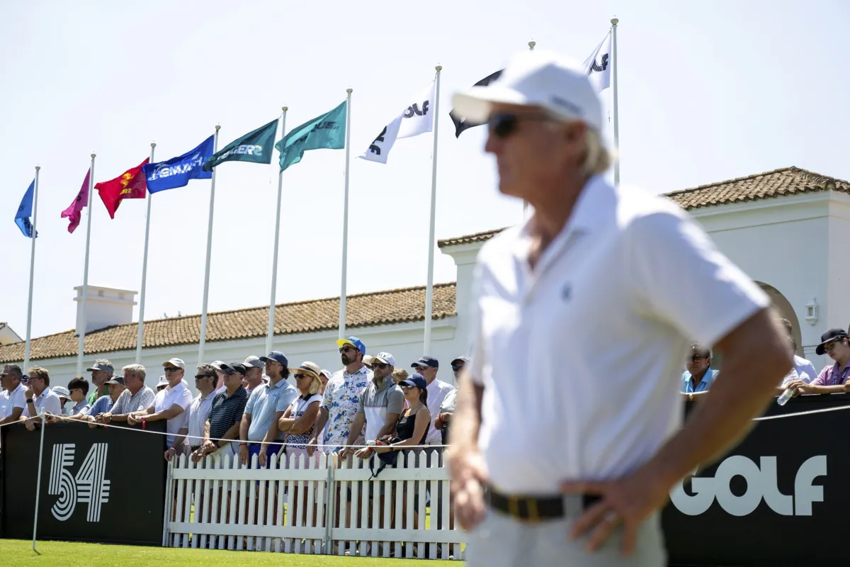 Fans watch as LIV Golf CEO Greg Norman looks on from the driving range before the first round of an LIV golf tournament at the Real Club Valderrama in San Roque, Spain, on June 30, 2023. (Matthew Harris/LIV Golf via AP)