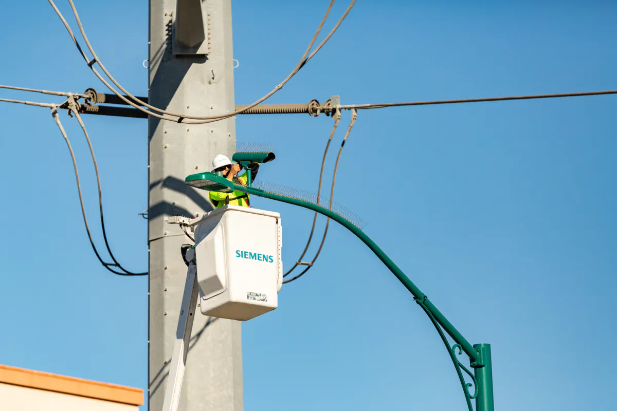 A worker fixes a traffic camera in Anaheim, Calif., on Feb. 23, 2021. (John Fredricks/The Epoch Times)
