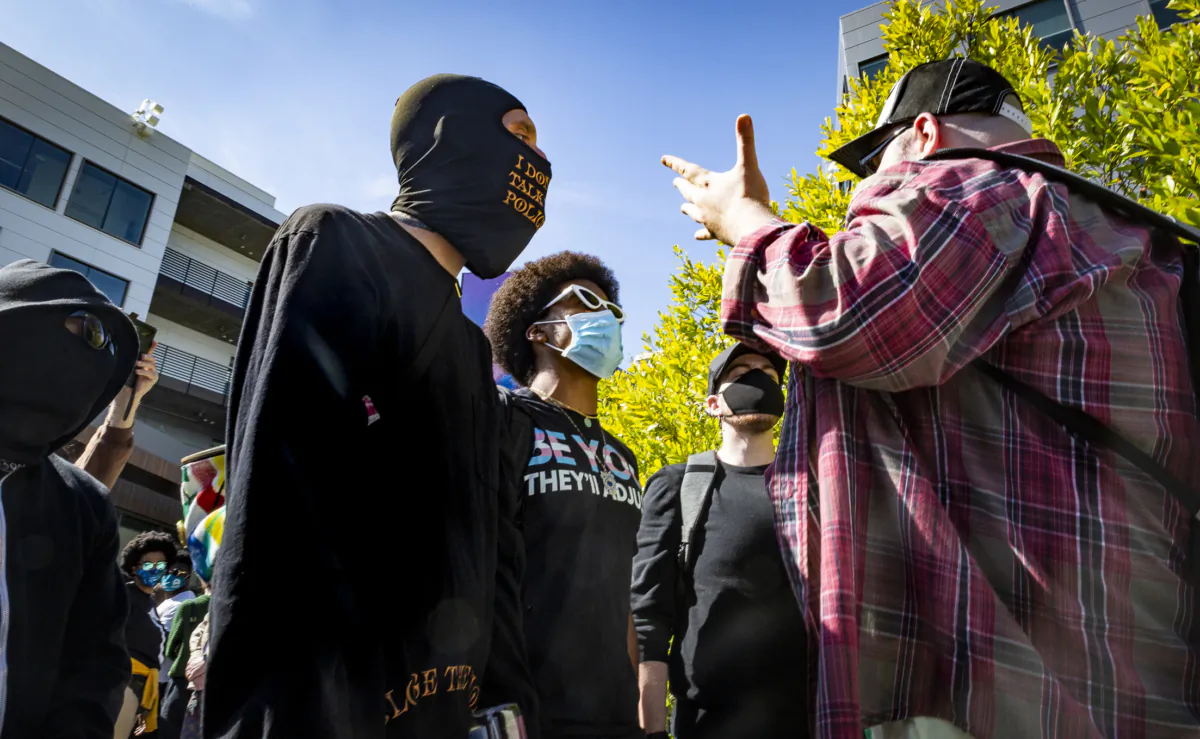 Protesters dressed in black confront a man in Los Angeles, Calif., on Oct. 21, 2021. (John Fredricks/The Epoch Times)