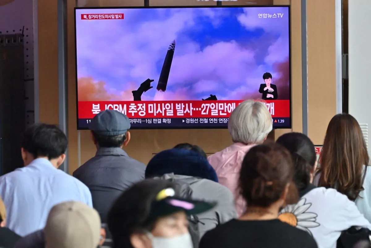 People watch a television screen showing a news broadcast with file footage of a North Korean missile test, at a railway station in Seoul, South Korea, on July 12, 2023. (Jung Yeon-Je/AFP via Getty Images)