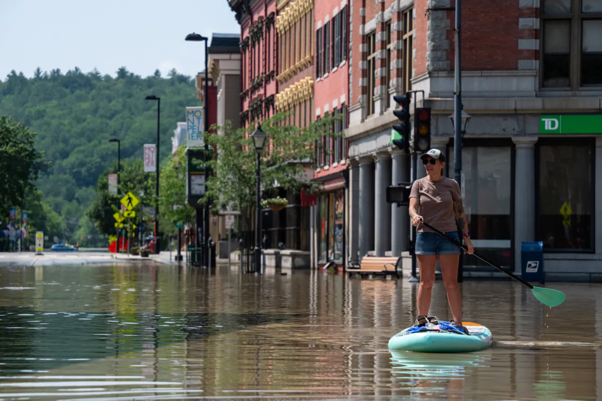 Montpelier resident Lynnea Timpone on a paddleboard at the intersection of Main Street and East State Street in Montpelier, Vt., on July 11, 2023. (Kylie Cooper/Getty Images)