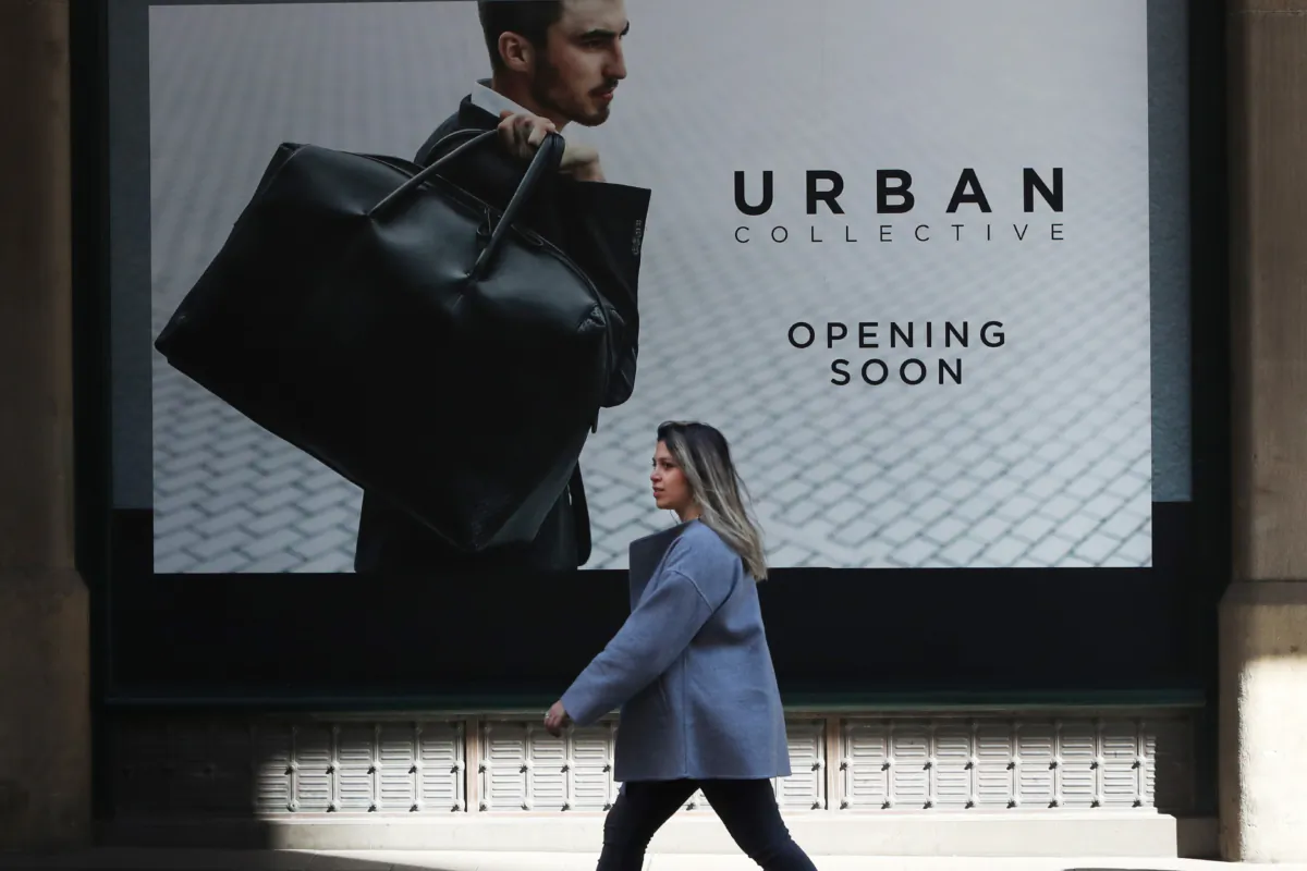 A pedestrian moves past a shop window in Sydney, Australia, on Aug. 16, 2022. (Lisa Maree Williams/Getty Images)