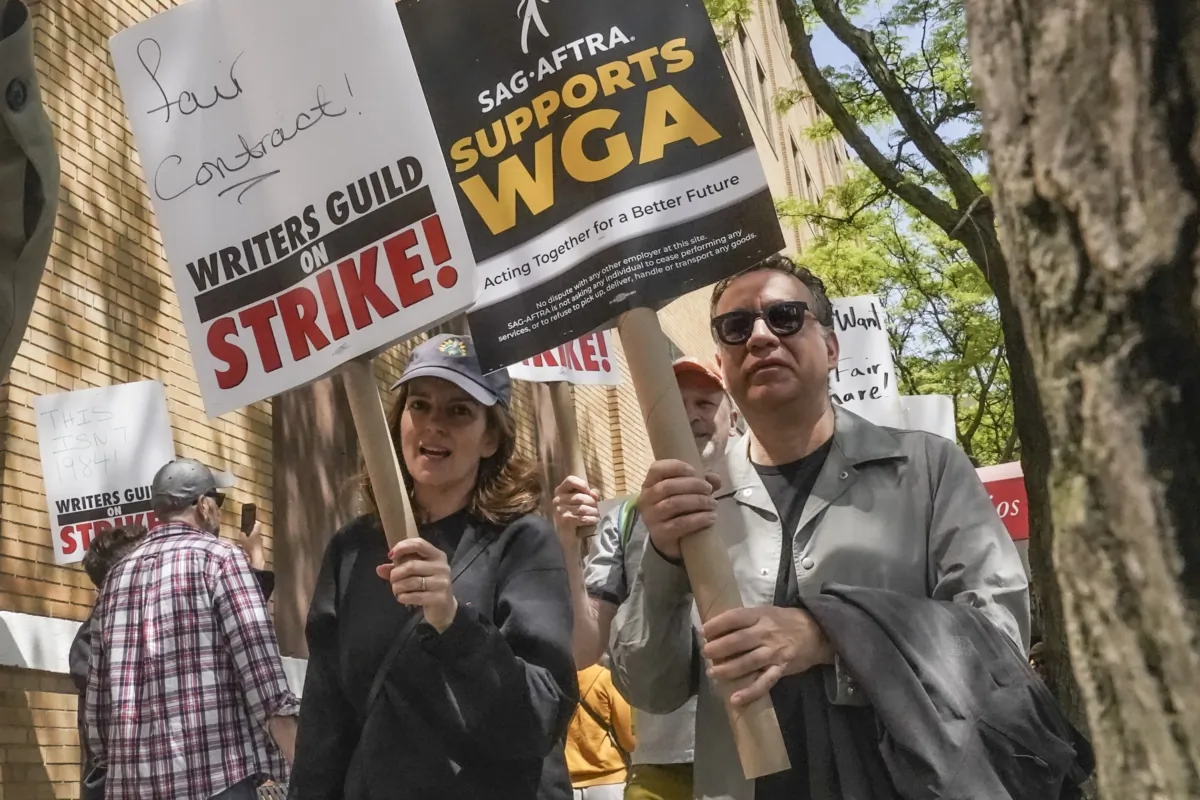 Actors and comedians Tina Fey (C) and Fred Armisen (R) join striking members of the Writers Guild of America on the picket line during a rally outside Silvercup Studios in New York on May 9, 2023. (Bebeto Matthews/AP Photo)