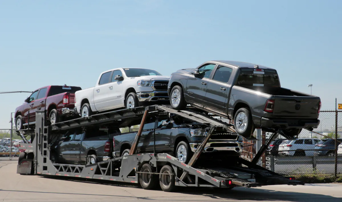 A car hauler in 2018 transports Dodge Ram pick-up trucks to a holding lot across from the FCA Jefferson North Assembly Plant in Detroit, Mich., on May 25, 2018. (Rebecca Cook/Reuters/File Photo)