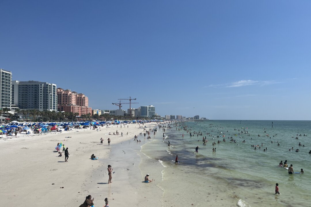 Tourists and locals play in the surf and sand in Clearwater Beach, Fla., on July 2, 2023. (Nanette Holt/The Epoch Times)