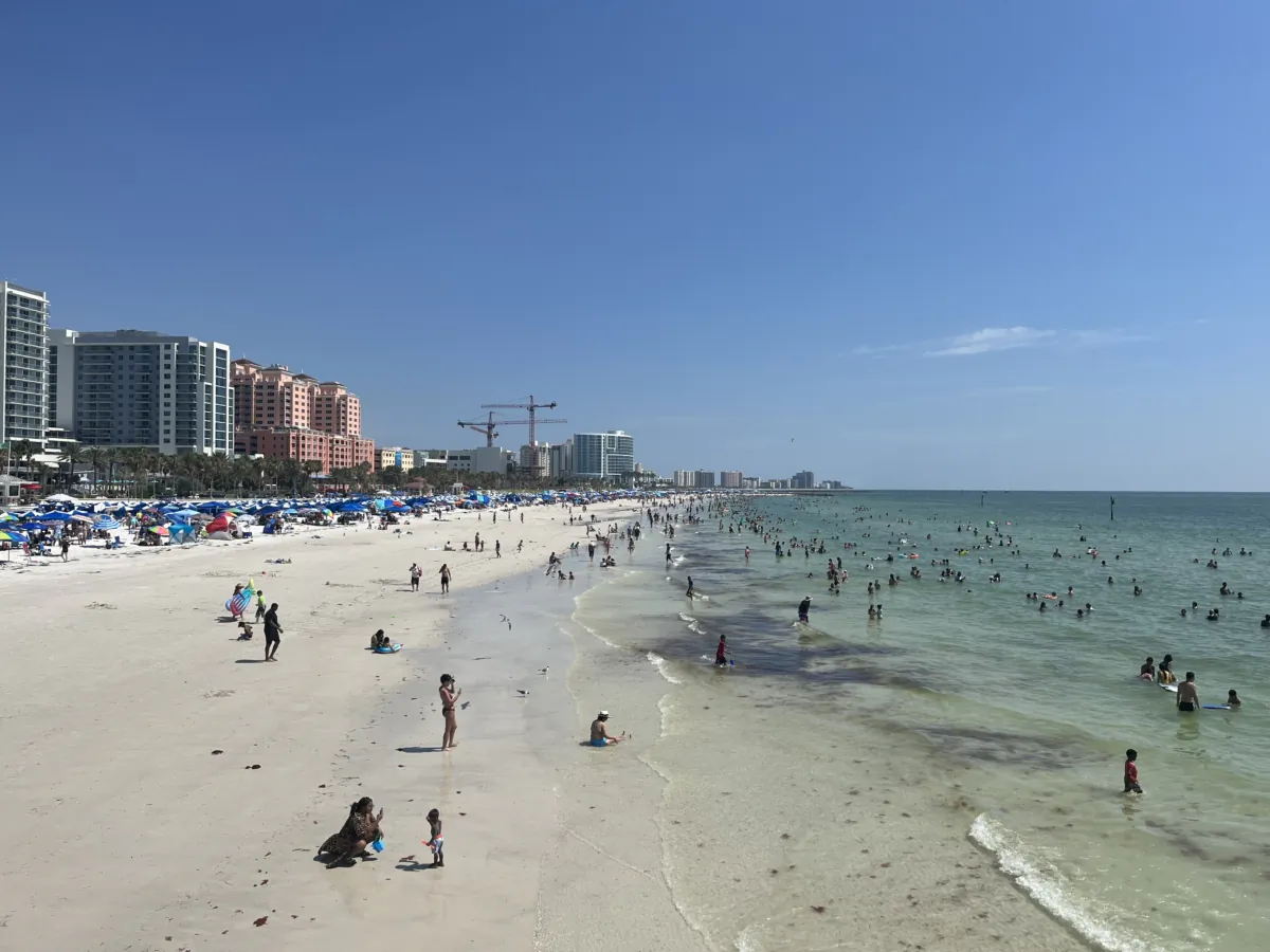 Tourists and locals play in the surf and sand in Clearwater Beach, Fla., on July 2, 2023. (Nanette Holt/The Epoch Times)