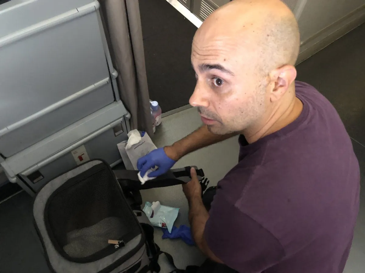 Habib Battah is seen on an Air France flight from Paris to Toronto in a June 30, 2023, handout photo, as he is cleaning blood off his pet carrier backpack that had transferred from the plane carpet from a previous passengers hemorrhage. (The Canadian Press/HO-Habib Battah)
