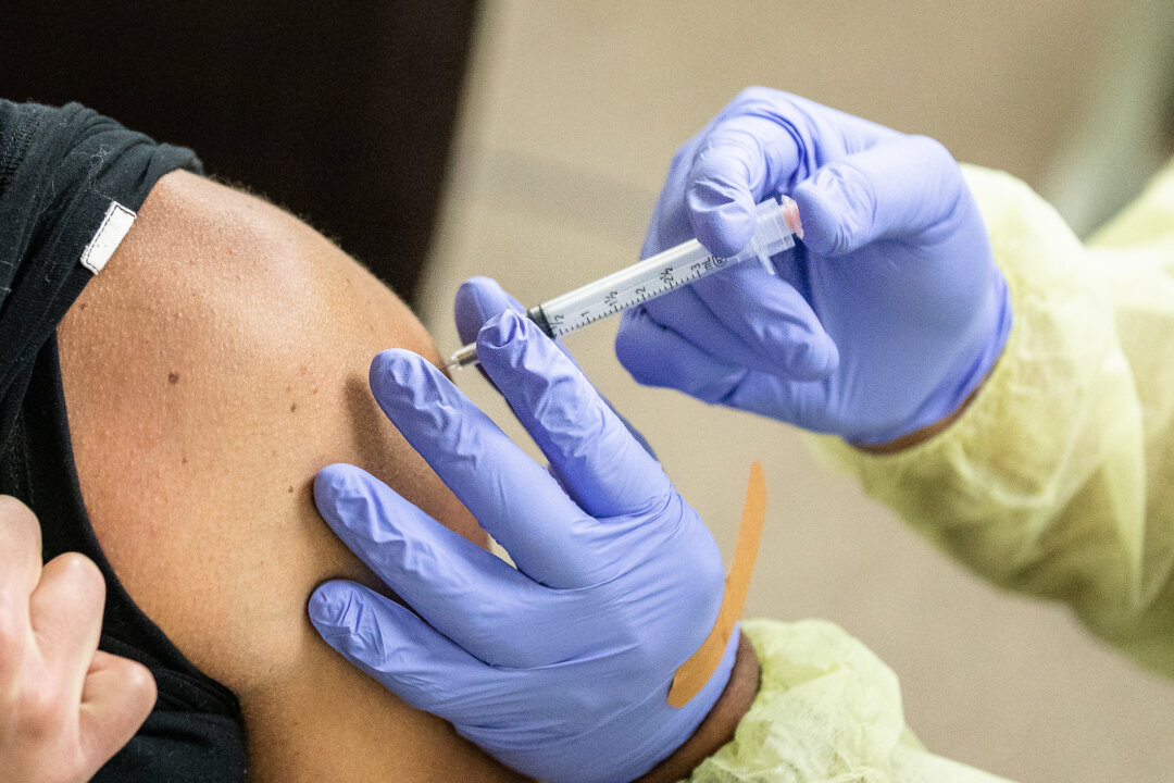 A medical volunteer prepares the Moderna coronavirus vaccination for a first responder in Orange, Calif., on March 9, 2021. (John Fredricks/The Epoch Times)