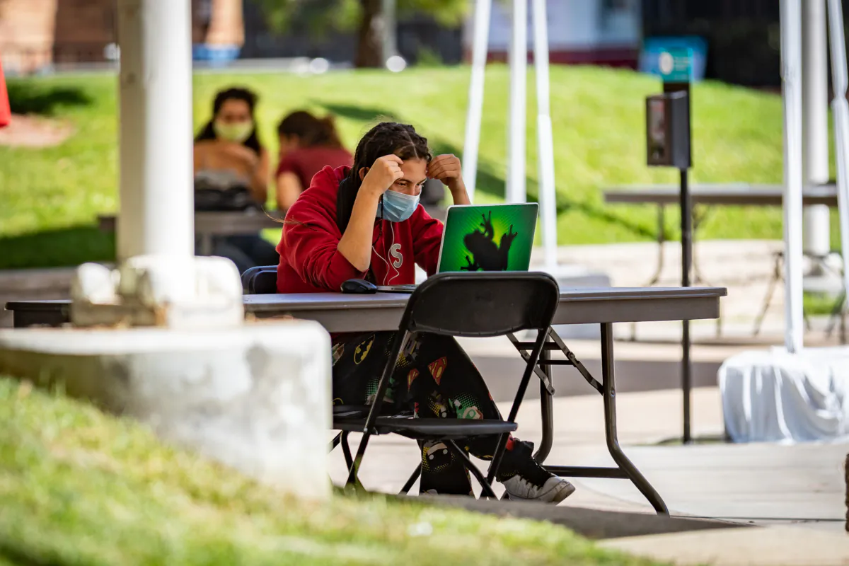 A student works outside on his laptop at Chapman University in Orange, Calif., on Oct. 14, 2020. (John Fredricks/The Epoch Times)