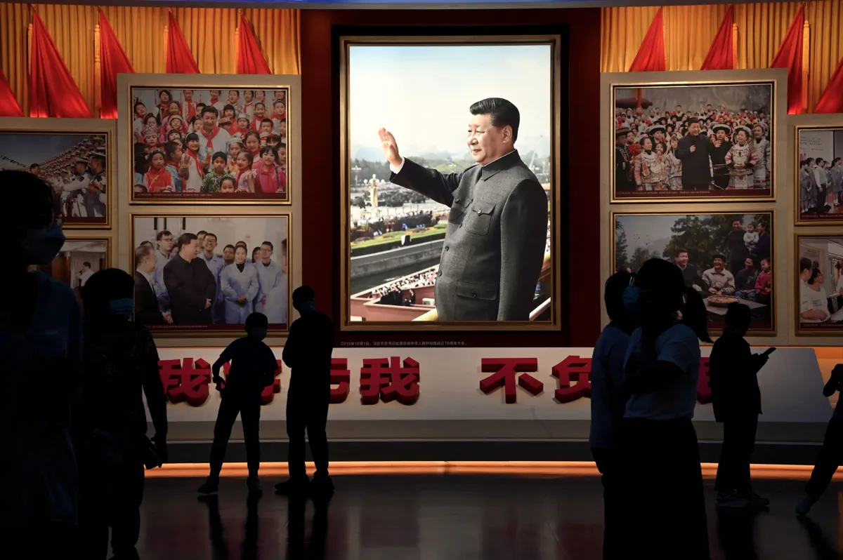 People stand in front of images of Chinese leader Xi Jinping at the Museum of the Communist Party of China in Beijing on Sept. 4, 2022. (Noel Celis /AFP via Getty Images)