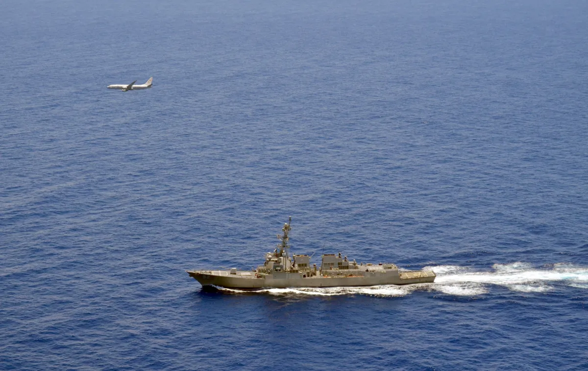 A P-8A Poseidon attached to Maritime Patrol Squadron (VP) 8 flies over the guided-missile destroyer USS Momsen (DDG 92) in the South China Sea on June 29, 2016. (Naval Aircrewman 2nd Class Daniel Rodriguez/U.S. Navy via Reuters)