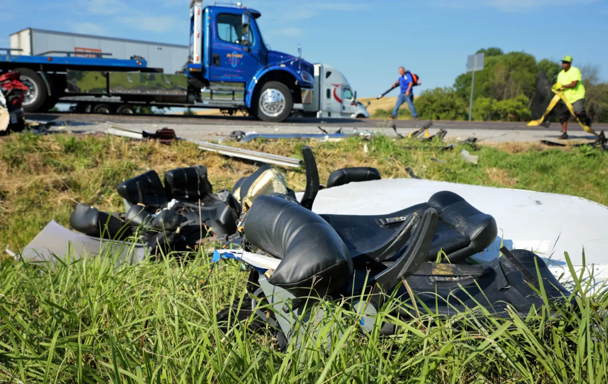 Workers clear debris from westbound Interstate 70 near Highland, Ill., on July 12, 2023, after a Greyhound passenger bus collided with a tractor-trailer. (Christian Gooden/St. Louis Post-Dispatch via AP)