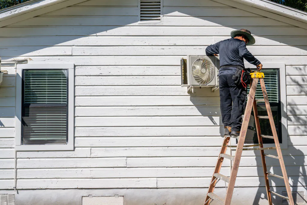 A technician repairs an air conditioning unit in Austin, Texas, on July 10, 2023. (Brandon Bell/Getty Images)