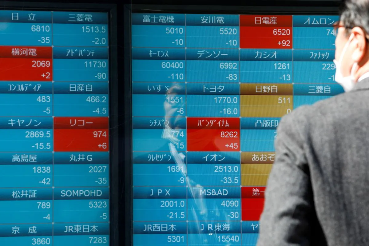 A man watches stock quotations on an electronic board outside a brokerage, in Tokyo, Japan, on March 20, 2023. (Androniki Christodoulou/Reuters)