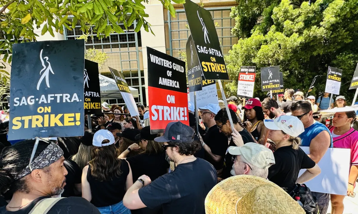 Members of the Screen Actors Guild-American Federation of Television and Radio Artists (SAG-AFTRA) on strike hold signs in front of Warner Bros. Studios in Burbank, Calif., on July 14, 2023. (Jill McLaughlin/The Epoch Times)