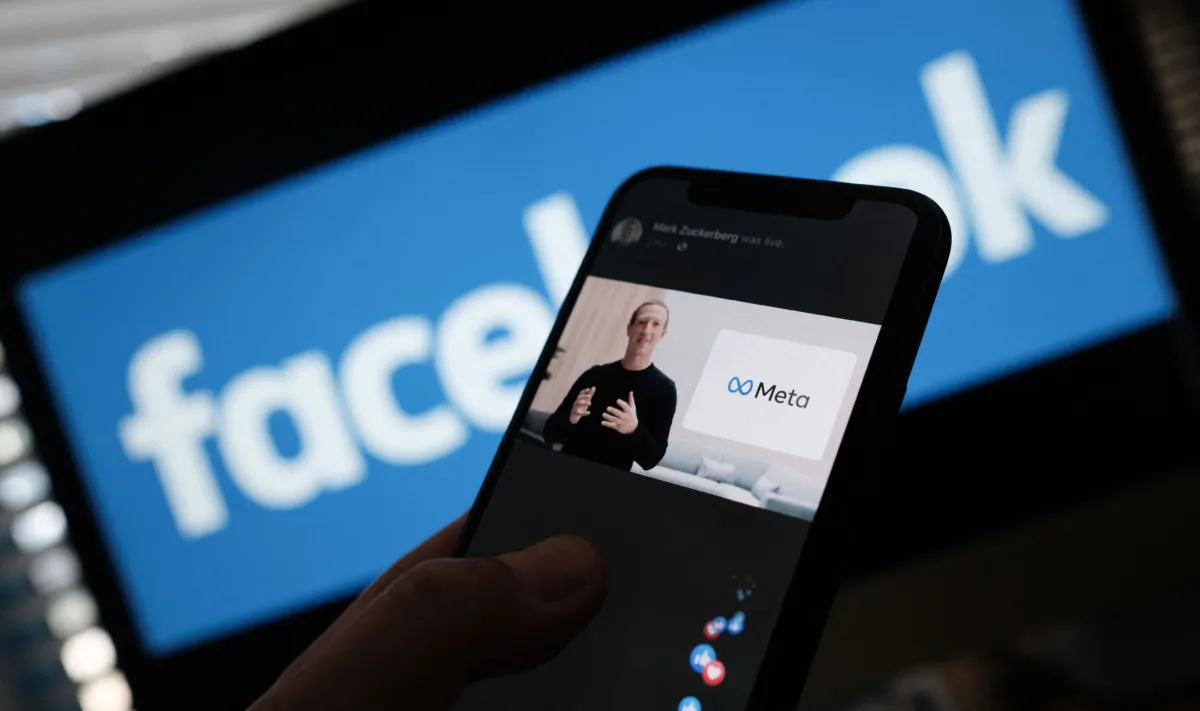 A person watches on a smartphone Facebook CEO Mark Zuckerberg unveiling the META logo in Los Angeles, Calif., on Oct. 28, 2021. (Chris Delmas/AFP via Getty Images)