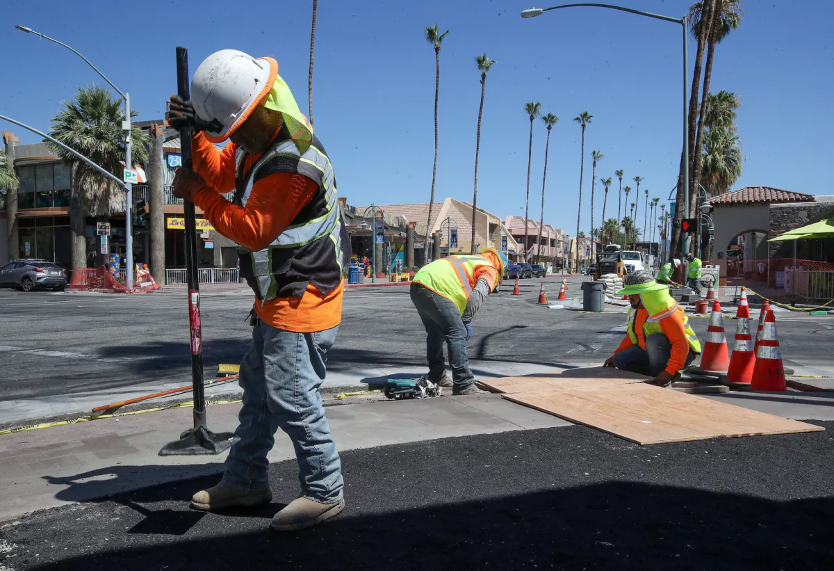 Construction workers install new sidewalks in downtown Palm Springs, California, in July 2023, one of about 35,000 infrastructure projects either under way or set to break ground as $700 billion in federal money begins to matriculate through states, counties, and cities nationwide. (Jay Calderon/USA Today Network via REUTERS)