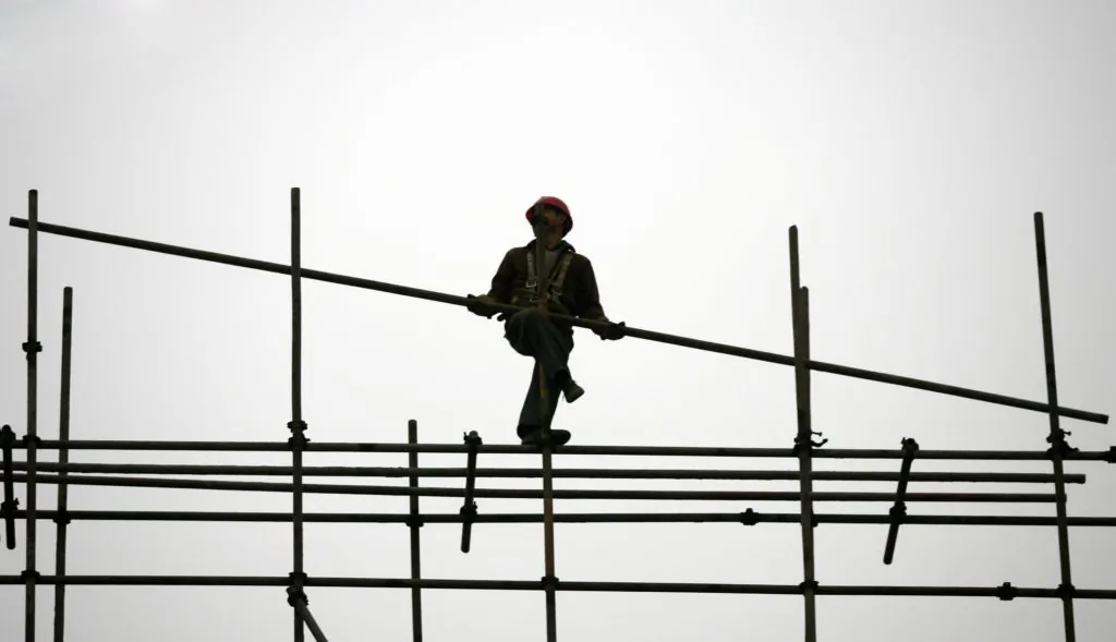 A migrant worker erects scaffoldings at a construction site in Chongqing Municipality, China, on Jan. 13, 2007. (China Photos/Getty Images)