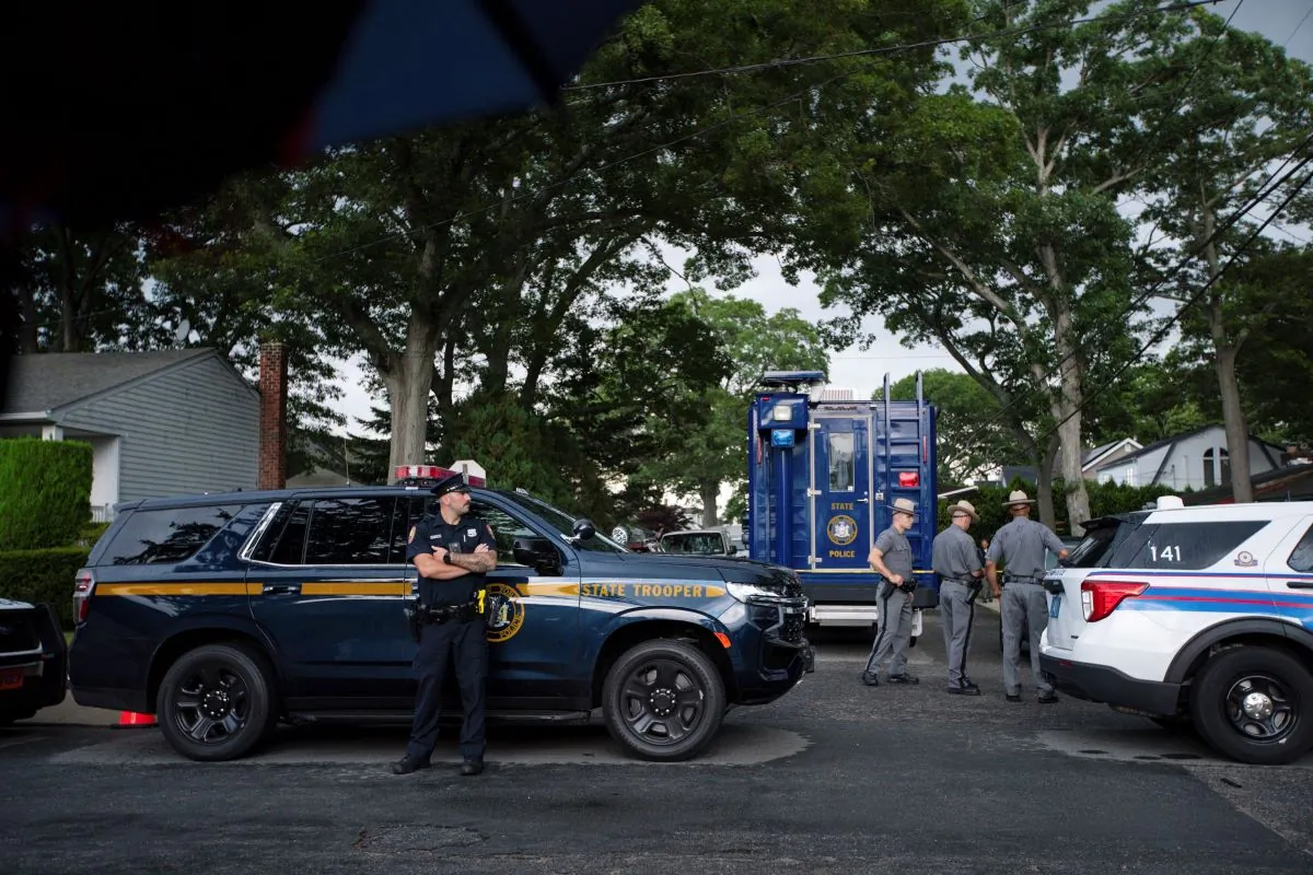 Police officers stand guard near the house where a suspect has been taken into custody on New York's Long Island in connection with the Gilgo Beach murders, in Massapequa Park, N.Y., on July 14, 2023, (Eduardo Munoz Alvarez/AP)