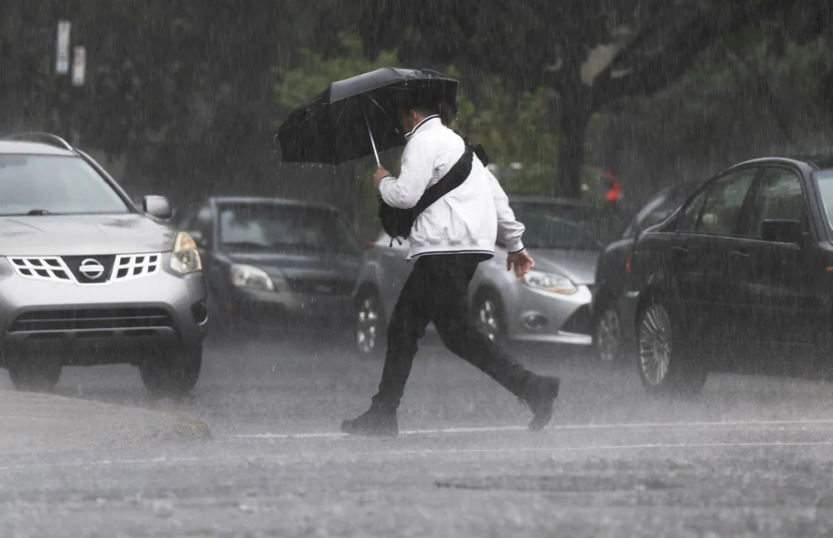 A pedestrians runs through a rainstorm July 13, 2023 in Montreal. (The Canadian Press/Ryan Remiorz)
