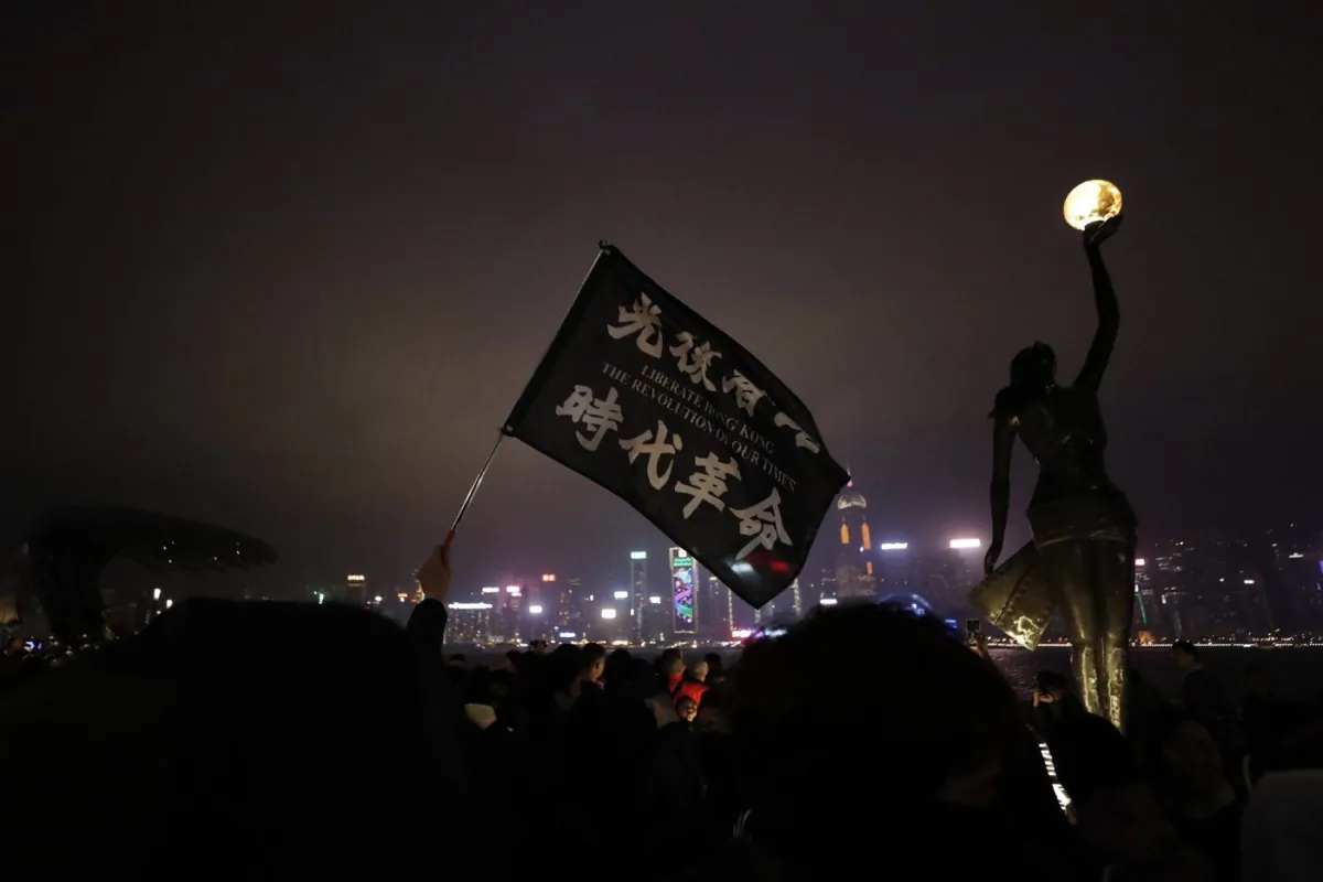 A protester holds a flag reading "Liberate Hong Kong, the Revolution of Our Times" during a demonstration in Hong Kong, Dec. 31, 2019. (The Canadian Press/AP-Lee Jin-man)
