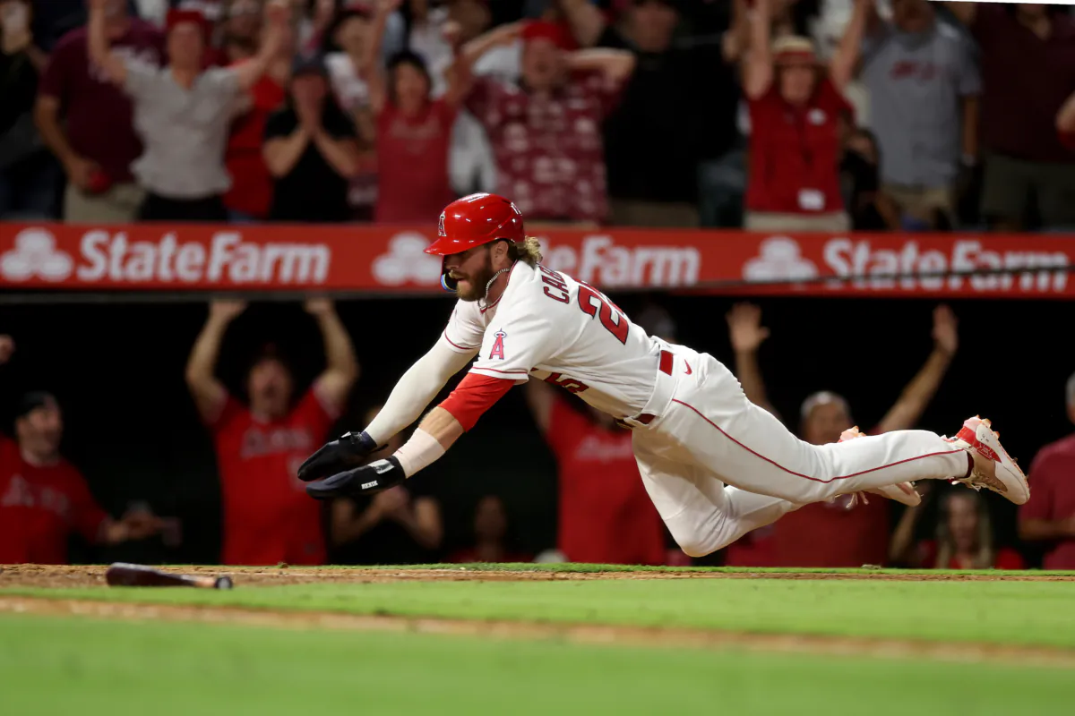 Trey Cabbage (25) scores on a single hit by Taylor Ward (3) of the Los Angeles Angels  during the tenth inning of a game against the Houston Astros at Angel Stadium of Anaheim in Anaheim, Calif., on July 15, 2023. (Sean M. Haffey/Getty Images)