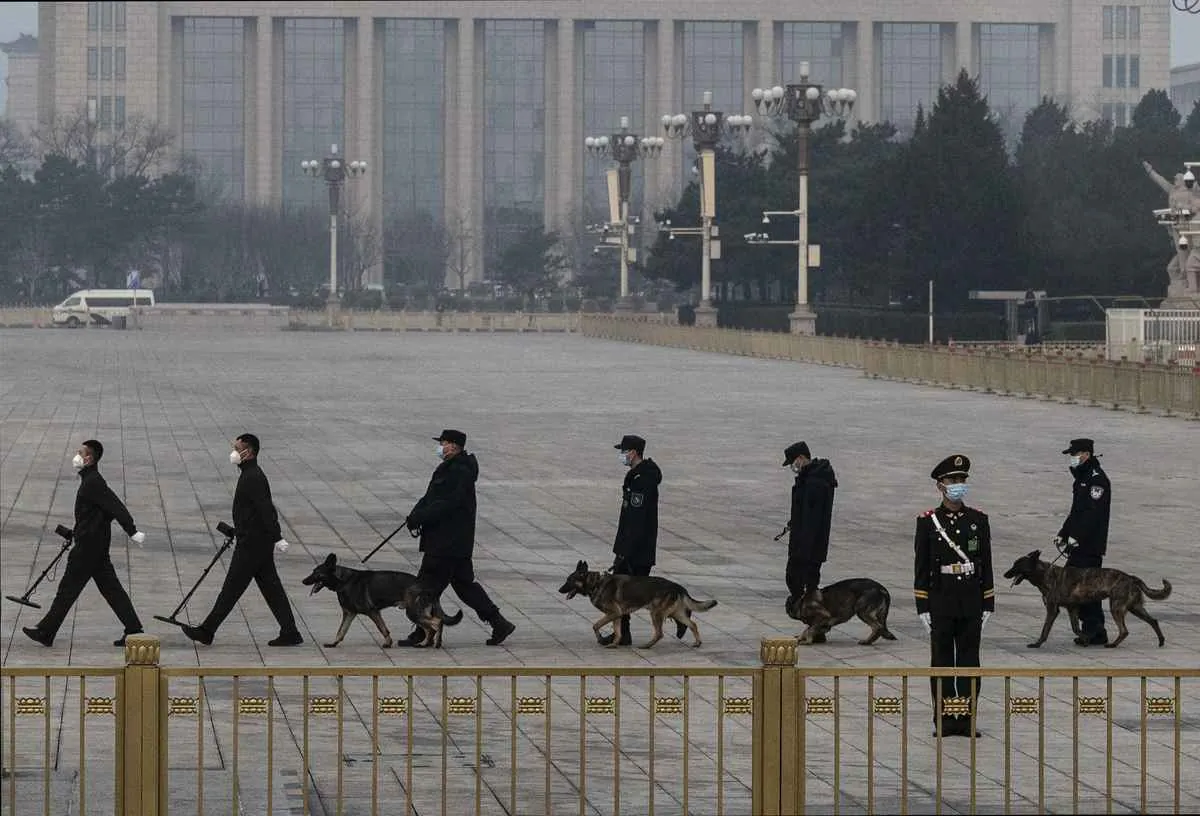 CCP police officers, accompanied by police dogs, conduct security scans at Tiananmen Square in Beijing, China, on March 10, 2022. (Kevin Frayer/Getty Images)