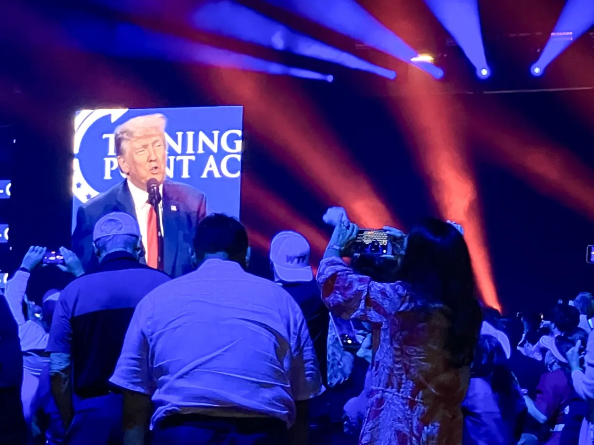 Audience members stand on chairs to photograph former President Donald Trump at a speech for the Turning Point Action Conference at the Palm Beach County Convention Center on July 15, 2023. (Janice Hisle/The Epoch Times)