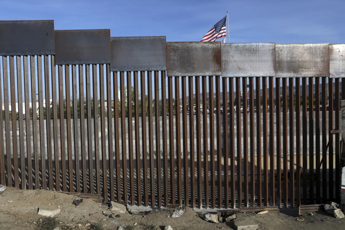 A U.S. flag flies behind the border fence that divides Mexico and the United States in Tijuana, Mexico, on Nov. 21, 2018. (Rodrigo Abd/AP Photo)
