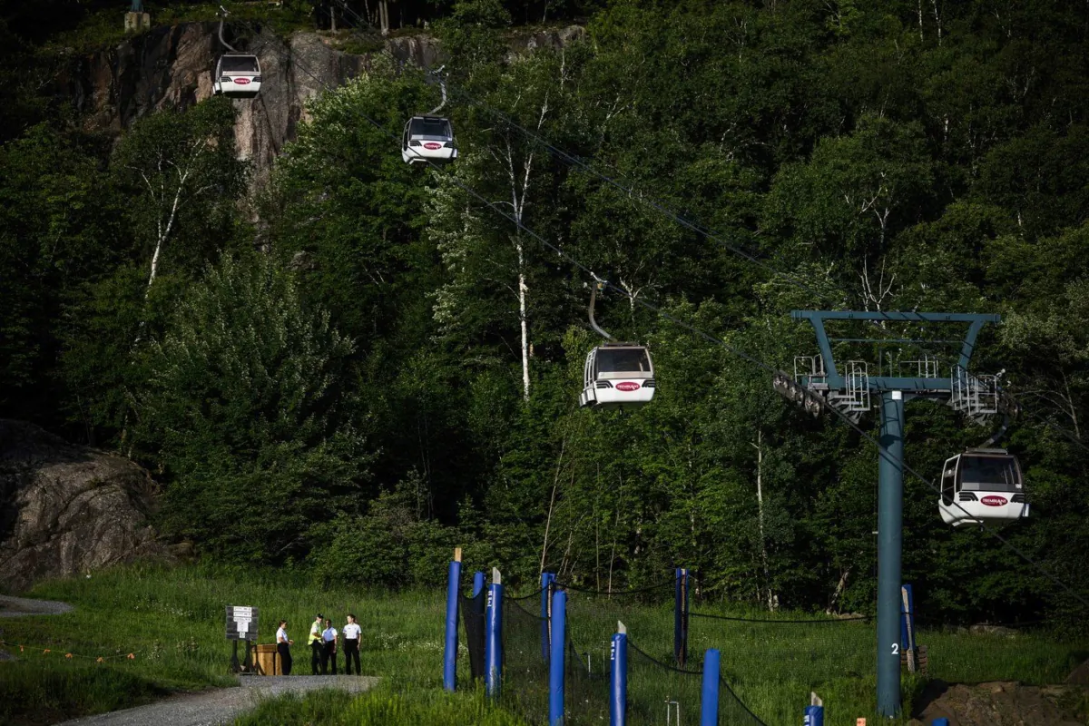 Cadets from the Surete du Quebec stand near the base of a chairlift where one person died and another remains critically injured after a gondola crashed into a piece of construction equipment at Mont-Tremblant Resort in Mont-Tremblant, Que., on July 16, 2023. (The Canadian Press/Justin Tang)