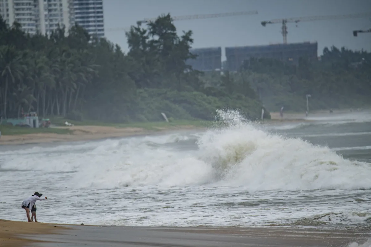 People watch big waves at a sea shore as Typhoon Talim approaches in Boao, in China's southern Hainan province on July 17, 2023. (CNS/AFP via Getty Images)