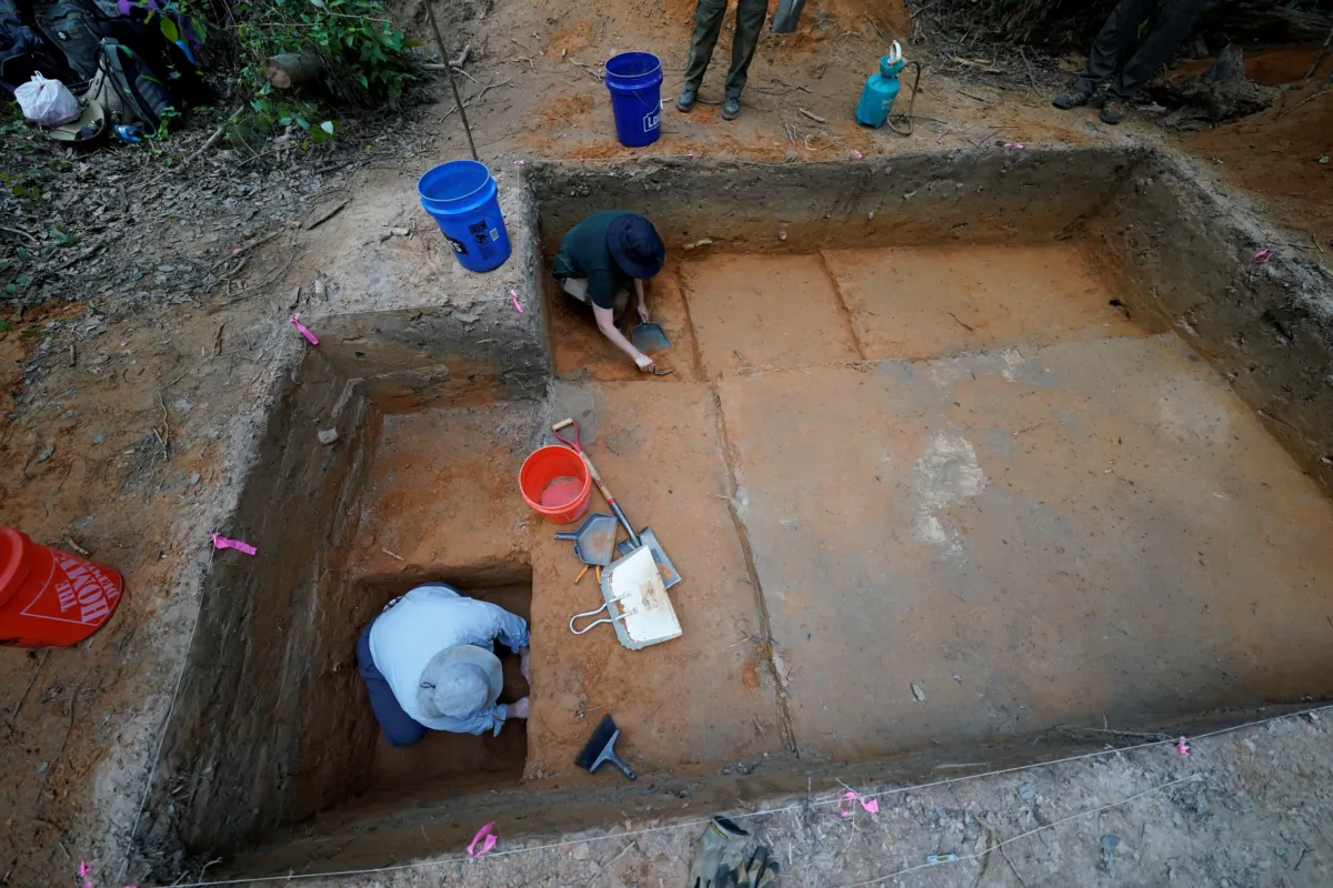 Gray Tarry, (bottom L) an archeological field technician for the University of Louisiana at Lafayette, digs on an archeological excavation site in Kisatchie National Forest, La., on June 7, 2023. (Gerald Herbert/AP Photo)