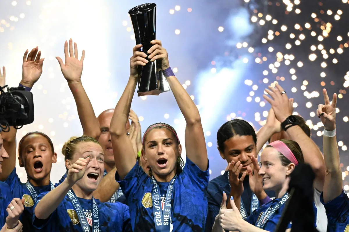 United States forward Alex Morgan (C) raises the SheBelieves Cup trophy as the United States Womens National Soccer Team celebrates following the 2023 SheBelieves Cup soccer match between the United States and Brazil at Toyota Stadium in Frisco, Texas, on Feb. 22, 2023. (Patrick T. Fallon/AFP via Getty Images)