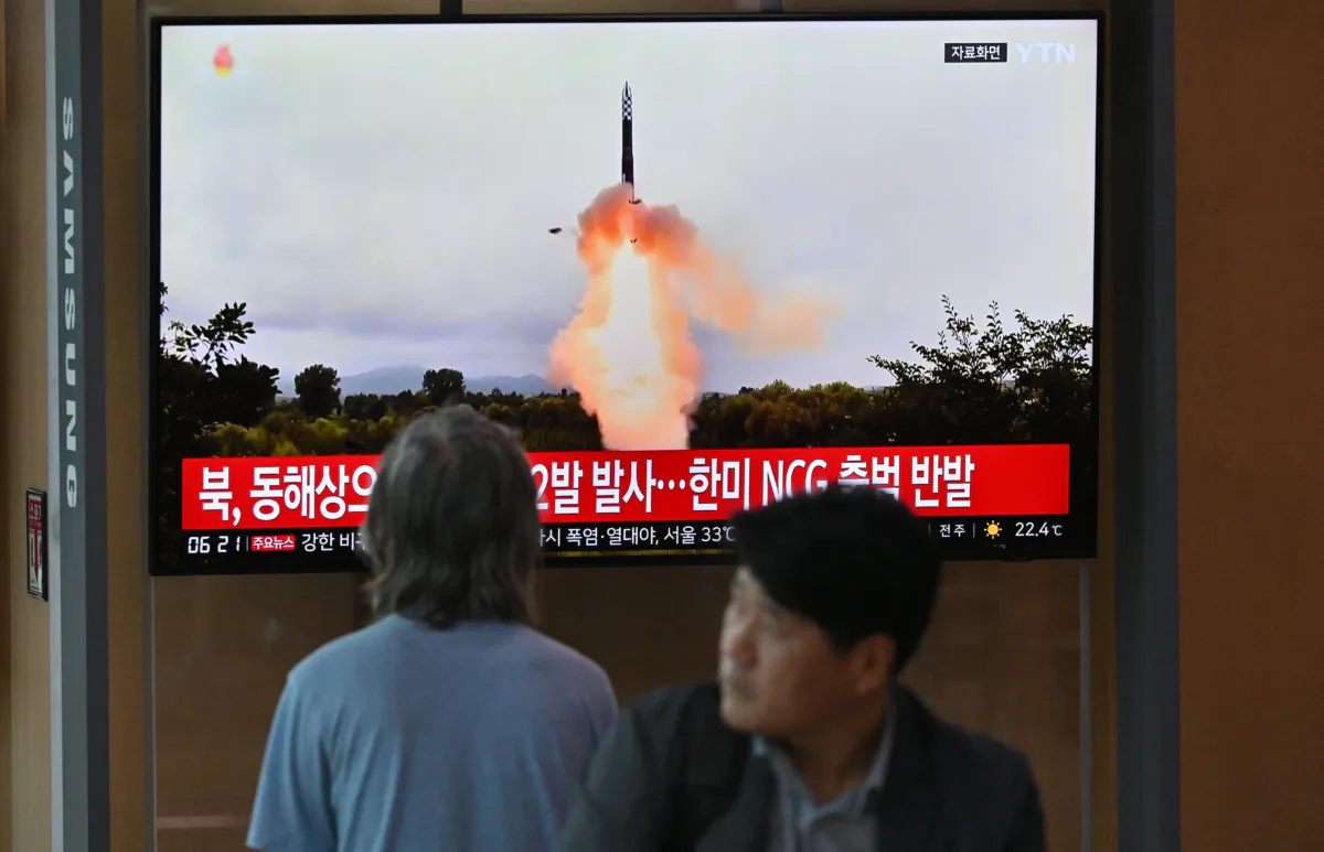 People watch a television screen showing a news broadcast with file footage of a North Korean missile test, at a railway station in Seoul, South Korea, on July 19, 2023. (Jung Yeon-je/AFP via Getty Images)