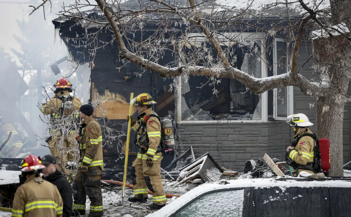 Firefighters attend the scene of a house explosion that injured several people, destroyed one home and damaged others in Calgary on March 27, 2023. (The Canadian Press/Jeff McIntosh)