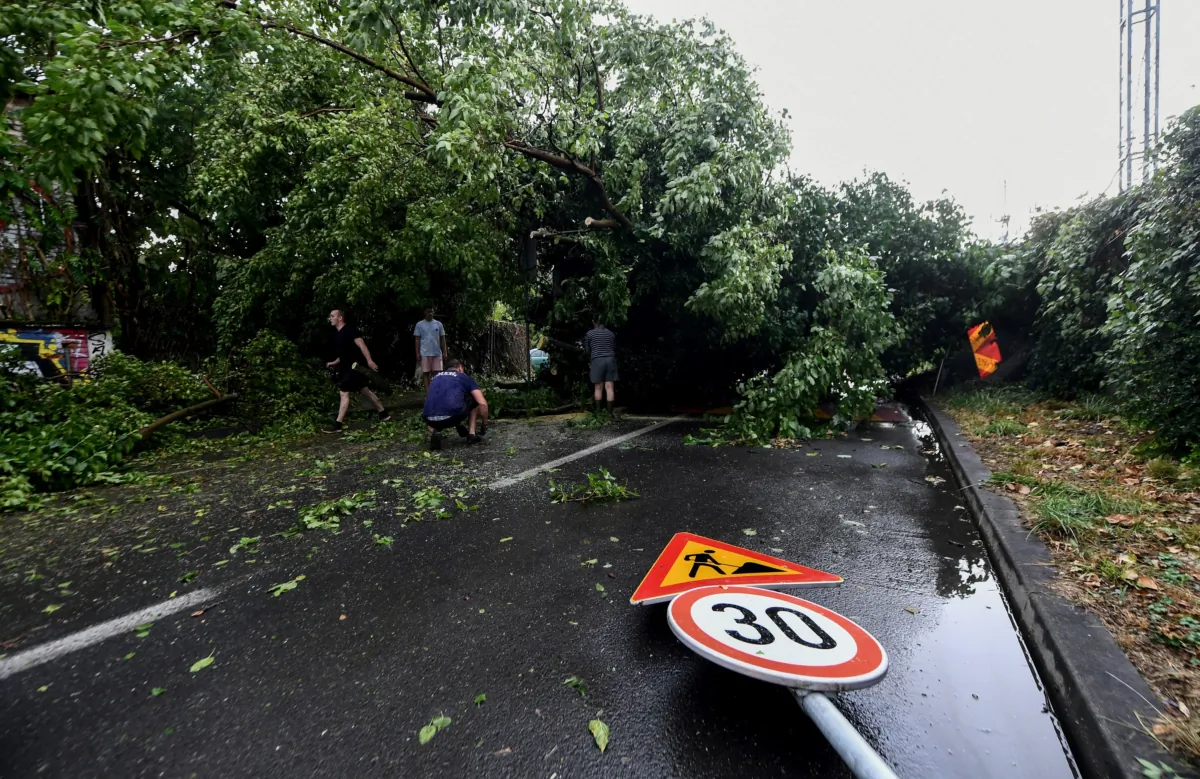 Local residents try to remove fallen trees from the road after a sudden storm in Zagreb, Croatia, on July 19, 2023. (Denis Lovrovic/AFP via Getty Images)