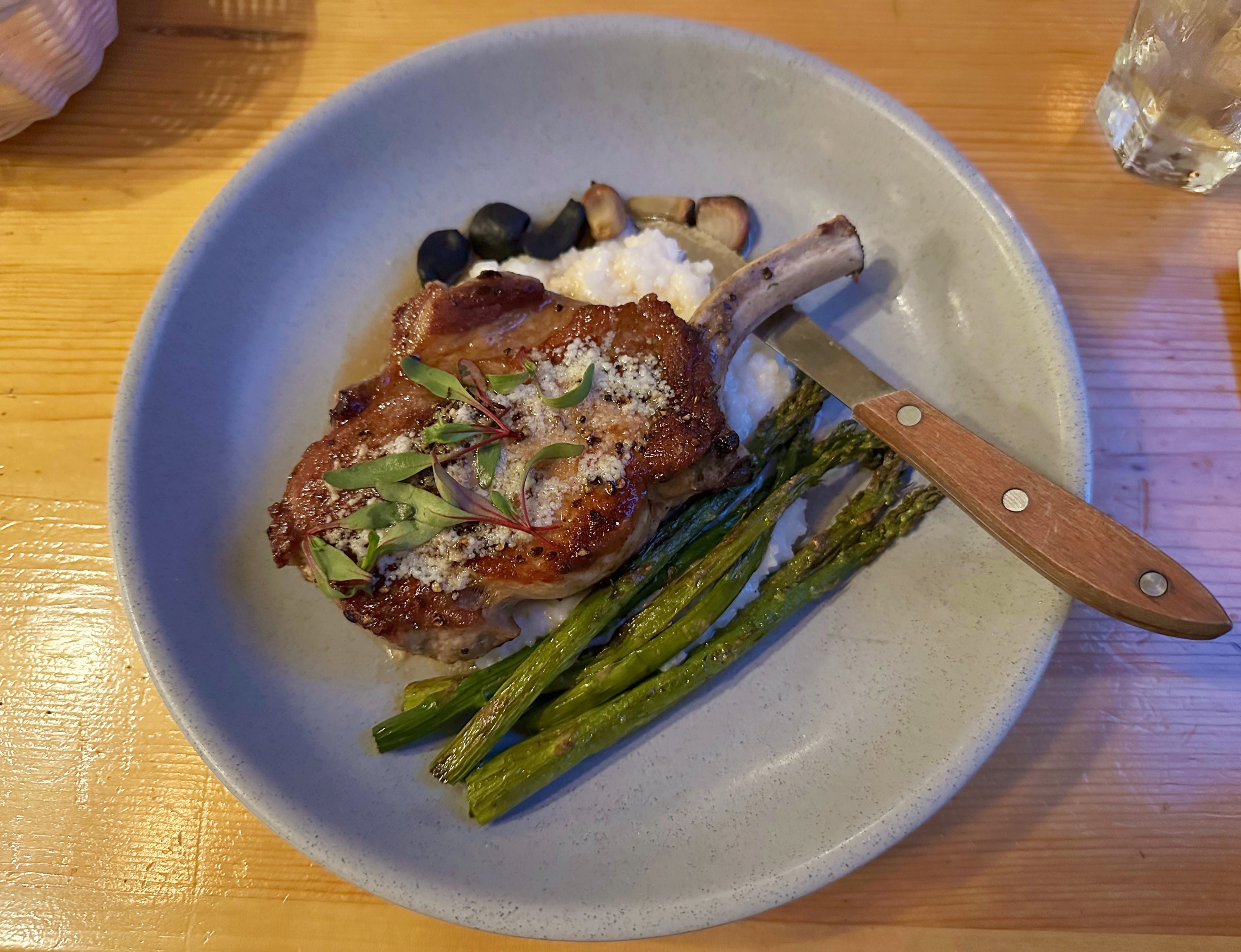 cast iron-seared pork chop served with cheesy rice and local asparagus. 