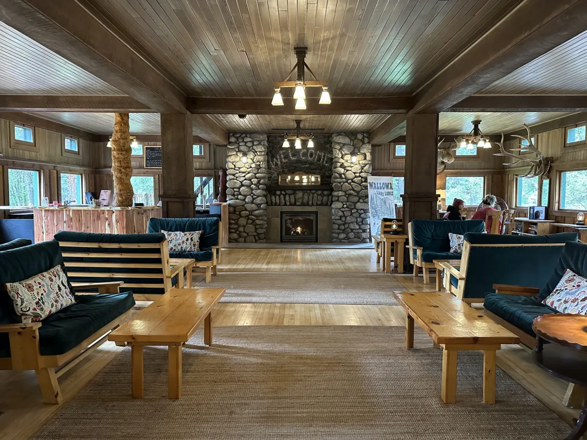 The cozy lobby of the century old Wallowa Lake Lodge features a roaring fireplace and plenty of green velvet couches to sink into with a good book. (Jackie Varriano/The Seattle Times/TNS)