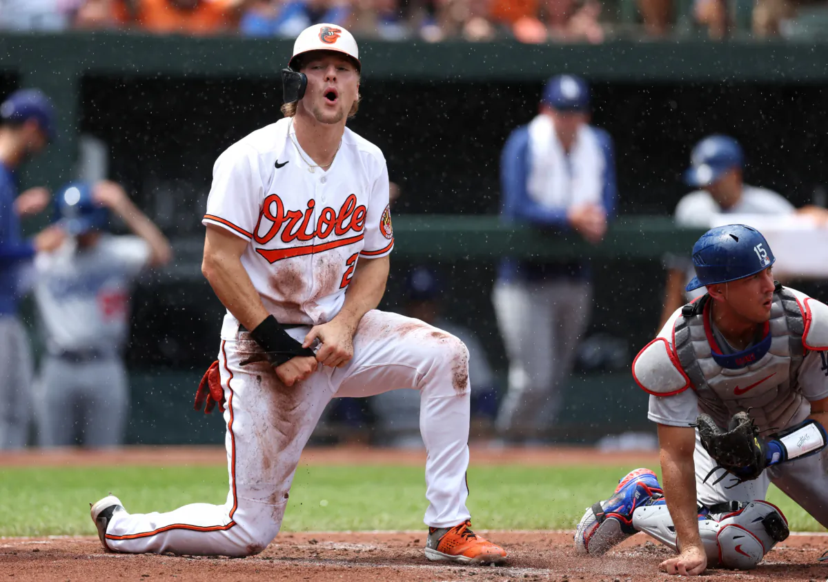Gunnar Henderson (2) of the Baltimore Orioles celebrates in front of catcher Austin Barnes (15) of the Los Angeles Dodgers after scoring a run in the first inning at Oriole Park at Camden Yards in Baltimore on July 19, 2023. (Rob Carr/Getty Images)