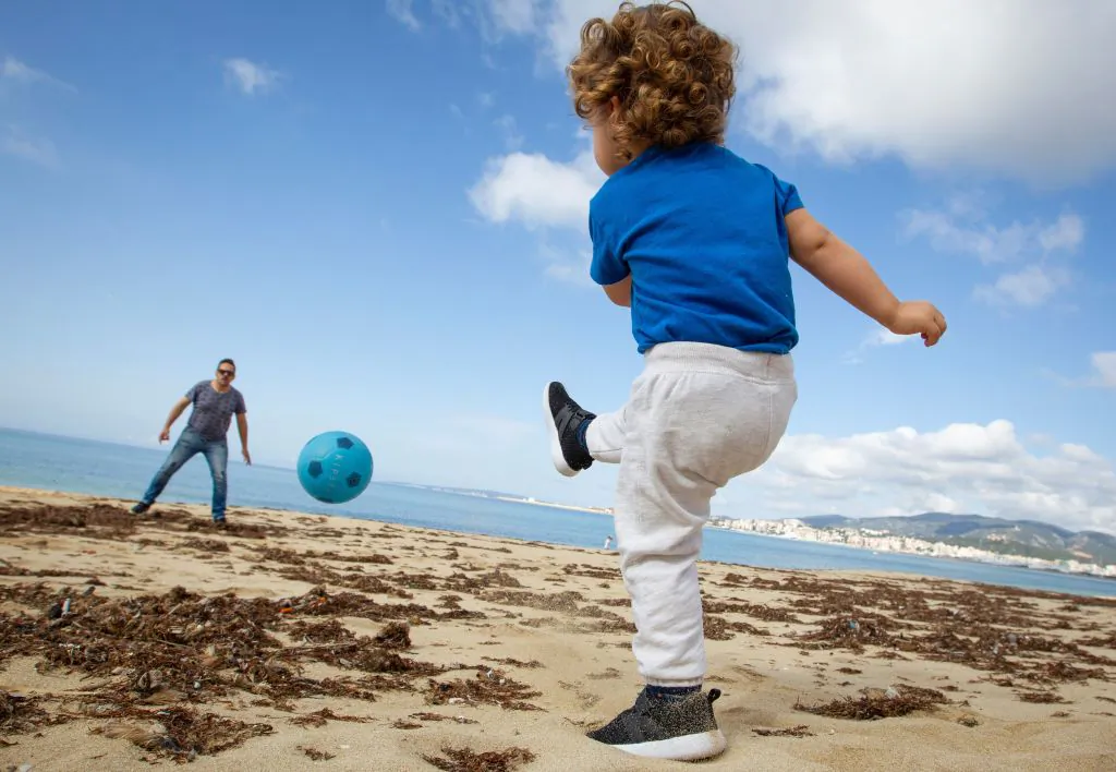 A child plays football with his father at Can Pere Antoni Beach in Palma de Mallorca, Spain, on April 26, 2020. (Jaime Reina/AFP via Getty Images)