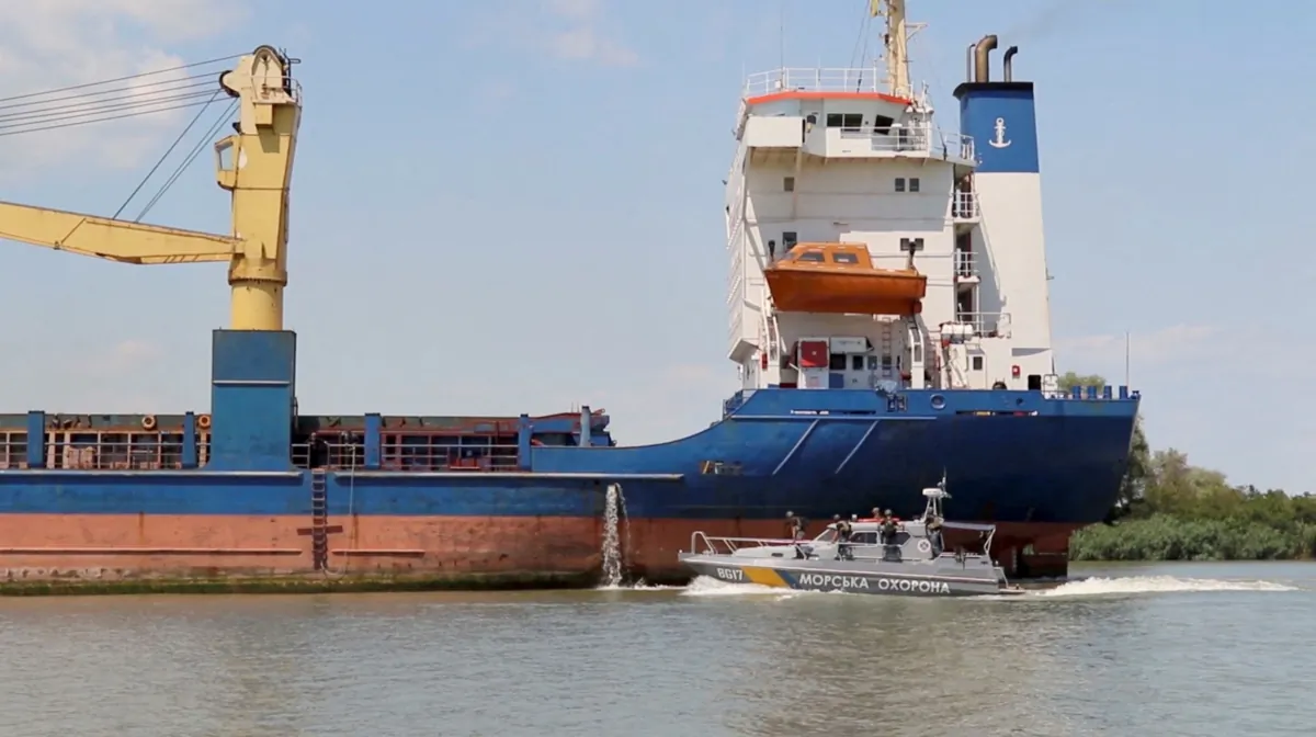 A cargo ship sails followed by a Ukrainian coast guard cutter through the Bystre rivermouth, which connects the Black Sea and Danube, in the Odesa region of Ukraine on July 15, 2022. (Operational Command South press service/Handout via Reuters)