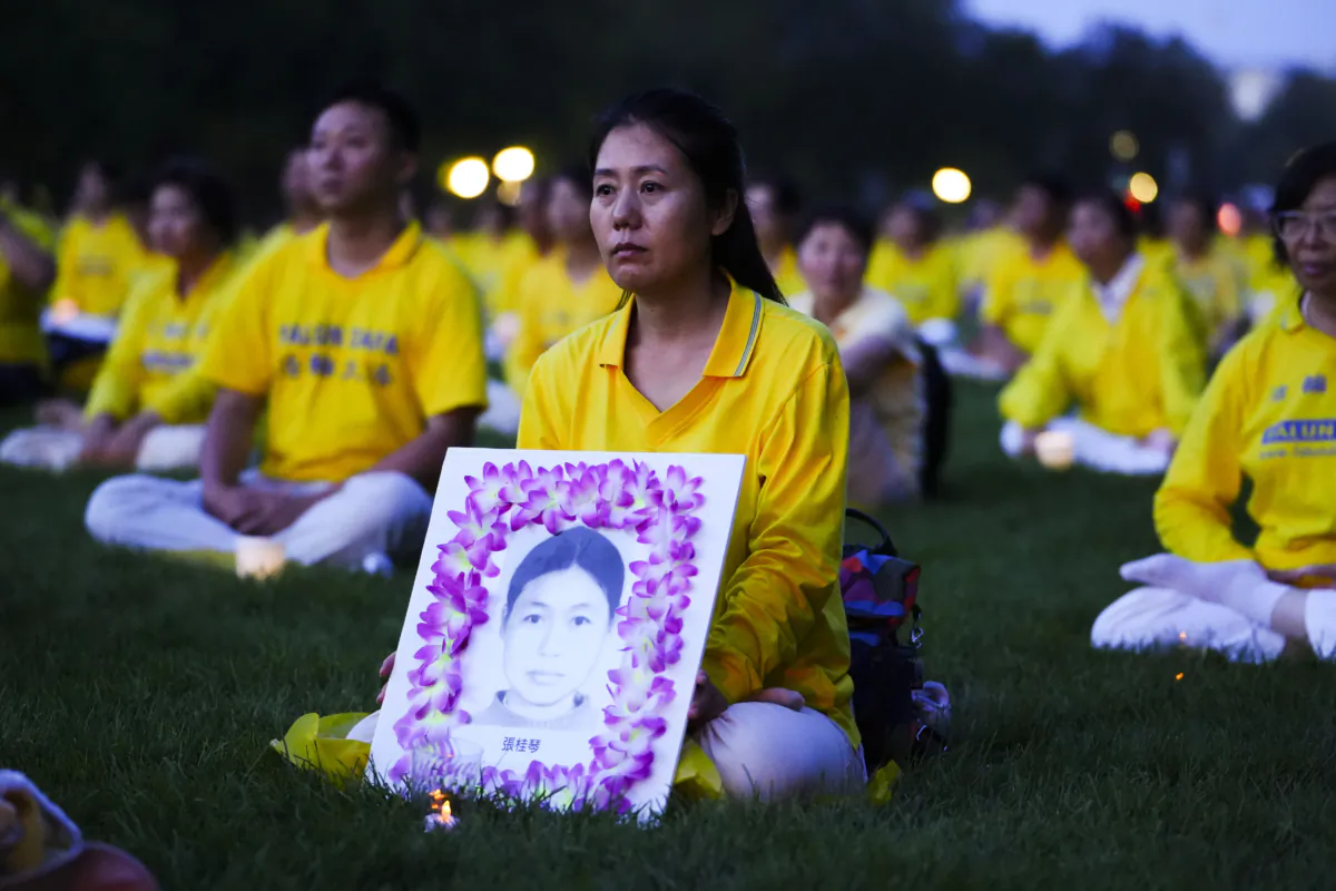 Falun Gong practitioners hold a candlelight vigil in memory of Falun Gong practitioners who passed away due to the Chinese Communist Party’s persecution, at the National Mall in Washington on July 20, 2023. (Madalina Vasiliu/The Epoch Times)