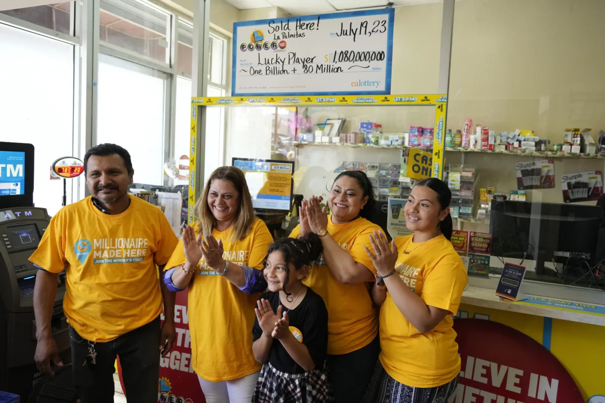 Store manager Navor Herrera (L) stands with family members, including wife and store owner Maria Menjivar (2nd L), stepdaughter Angelica Menjivar (2nd R), and Angelica's daughters Natalie Palacios (C), 9, and Sarai Palacios (R) inside the Las Palmitas Mini Market in downtown Los Angeles on July 20, 2023, where the winning Powerball lottery ticket, worth an estimated $1.08 billion, was sold. (Marcio Jose Sanchez/AP Photo)